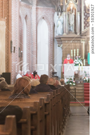 Holy mass with priest in traditional liturgical vestments and few elderly people in catholic cathedral church in Poland Holy mass with priest in traditional liturgical vestments and few elderly people in catholic cathedral church in Poland 58301927