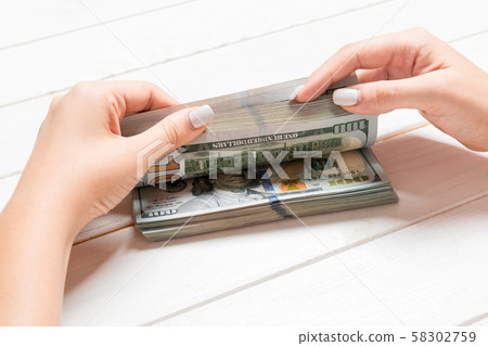 Businesswoman's hands counting one hundred dollar 58302759