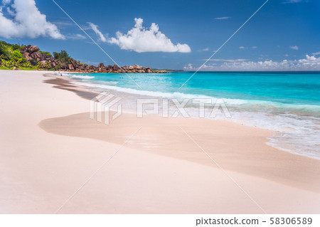 Grand Anse sandy exotic beach at La Digue island in Seychelles. Unrecognized tourists swimming and 58306589