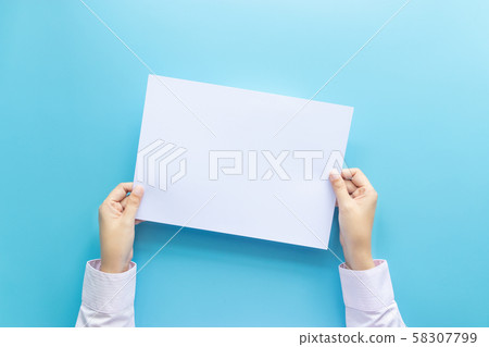 close up hands holding  empty white blank letter paper for flyer , presentation or invitation mock up isolated on a blue background. 58307799