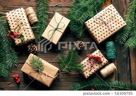 Christmas gifts and fir branches on a wooden background Christmas gifts and fir branches on a wooden background 58309795