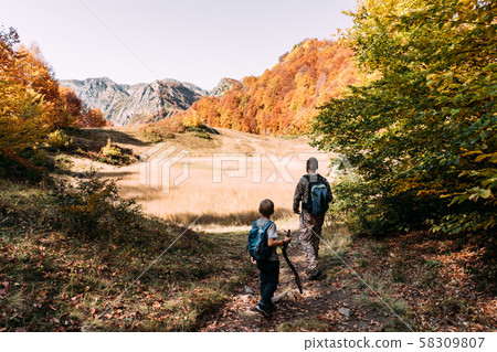 father and son in the mountains in the forest in autumn father and son in the mountains in the forest in autumn 58309807