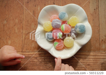 Colorful candy on Japanese tableware and a little girl's hand 58311220