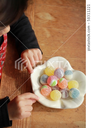 Colorful candy on Japanese tableware and a little girl's hand Colorful candy on Japanese tableware and a little girl's hand 58311221