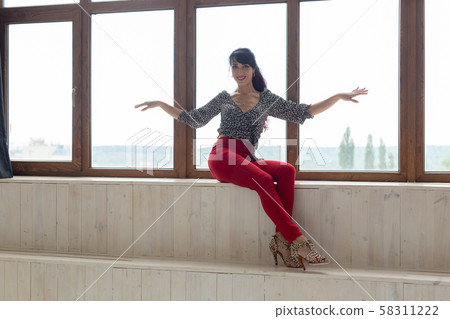 Beautiful pretty slim woman sitting by the window Beautiful pretty slim woman sitting by the window 58311222