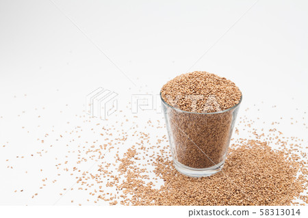 Sesame seeds in glass cup on a white 58313014