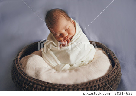 newborn baby wrapped in a blanket sleeping in a basket. concept of childhood, healthcare, IVF. Black and white photo 58314655