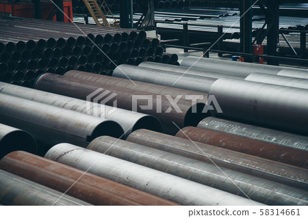 heavy industry concept, construction machinery - long metal pipes inside a large room. Building materials in the hangar heavy industry concept, construction machinery - long metal pipes inside a large room. Building materials in the hangar 58314661