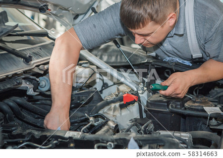 Car repair and cleaning concept - car engine close-up, wiping parts under the hood 58314663