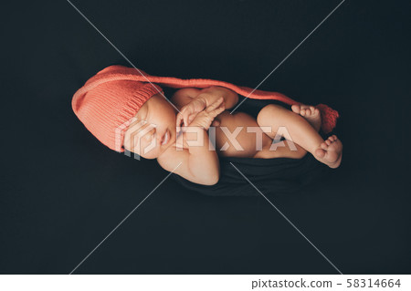 a newborn baby sleeps in a red Christmas hat on a black background. the concept of a healthy lifestyle, ECO, Christmas, new year holidays 58314664