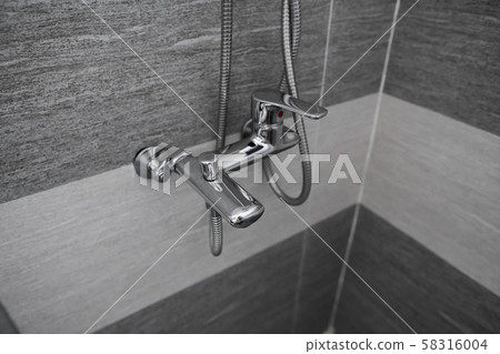 Modern designer tap and shower in bathroom. Closeup of chrome shower, faucet, in the bathroom 58316004