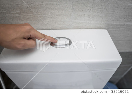 Close up of finger pushing a flush toilet button for cleaning a toilet. Close up of finger pushing a flush toilet button for cleaning a toilet. 58316051