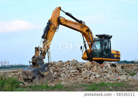 Excavator with crusher bucket for crushing concrete. Construction waste recycling Excavator with crusher bucket for crushing concrete. Construction waste recycling 58316111