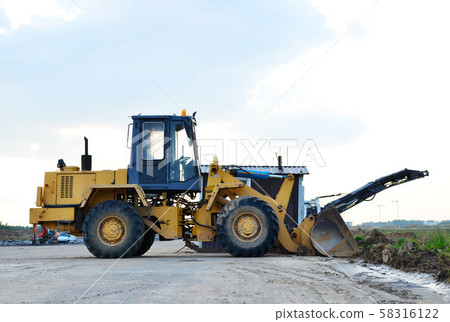 Wheel loader bulldozer with bucket on a construction site 58316122