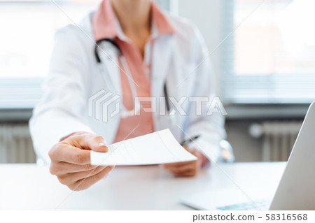 Doctor holding prescription paper into the camera 58316568