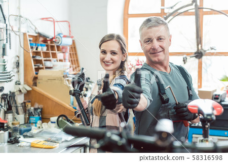 Two bike mechanics in their workshop having a successful day 58316598