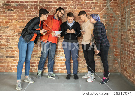 Group of happy young men and women sharing in social media 58317074