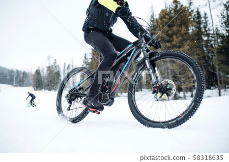 Midsection of mountain biker riding in snow outdoors in winter. 58318635