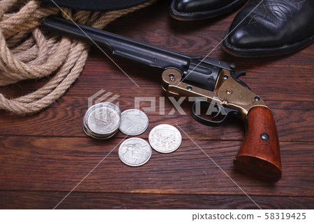 Old western gun with silver dollars with hat, rope 58319425