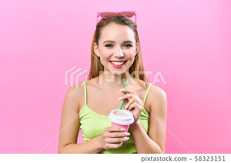 Portrait of a beautiful girl, with a cup of coffee, looking at the camera and smiling cute. Portrait of a beautiful girl, with a cup of coffee, looking at the camera and smiling cute. 58323151
