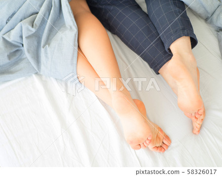 Couple in bed, sleeping. Close up feet. Couple in bed, sleeping. Close up feet. 58326017
