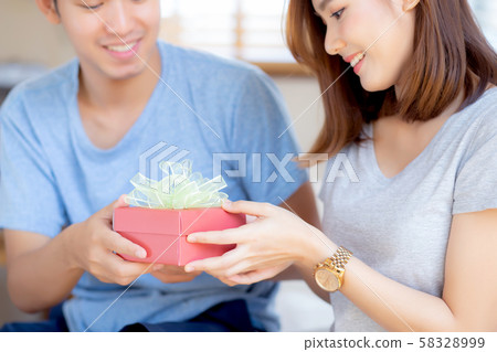 Beautiful young asian couple in love surprise gift box in bedroom at home Beautiful young asian couple in love surprise gift box in bedroom at home 58328999
