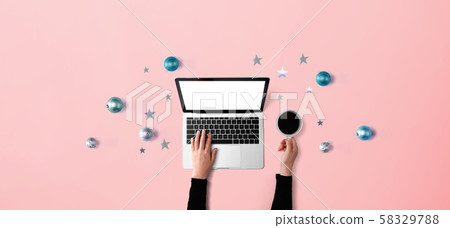 Christmas ornaments with person using a laptop computer 58329788