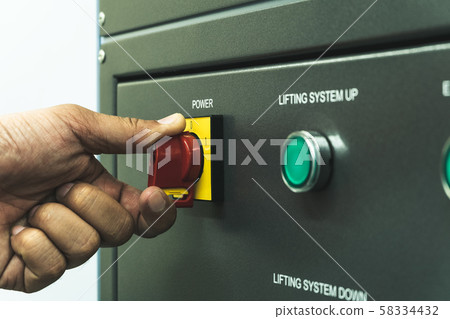 Close up of Worker hand twist main power switch before operating testing machine Close up of Worker hand twist main power switch before operating testing machine 58334432