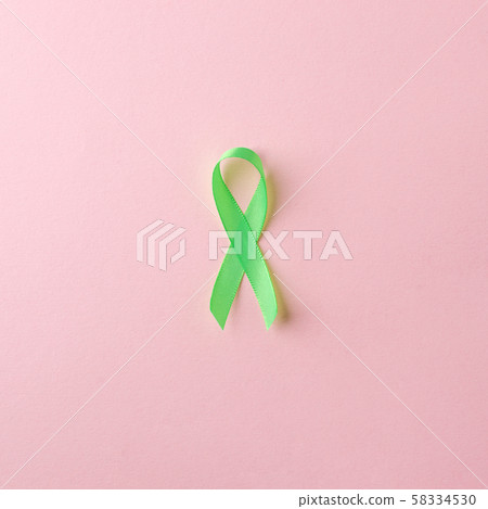 Green satin ribbon on pink background. Liver, 58334530
