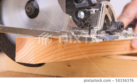 Cutting wood with an electric saw 58336376