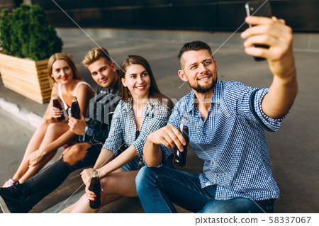 A group of cheerful friends, guys and girls walk A group of cheerful friends, guys and girls walk 58337067