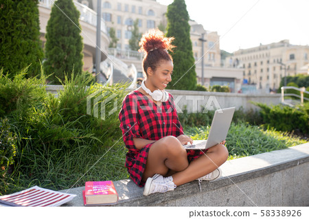 Stylish smart red-haired student watching online video 58338926
