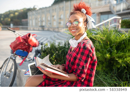 Student feeling inspired while reading interesting book Student feeling inspired while reading interesting book 58338949