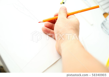 Male hand holding orange pencil ready to draw Male hand holding orange pencil ready to draw 58340903