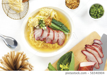Egg noodle and pork wonton soup with red roasted pork in white bowl and seasoning on white table top view and horizontal. Egg noodle and pork wonton soup with red roasted pork in white bowl and seasoning on white table top view and horizontal. 58340904