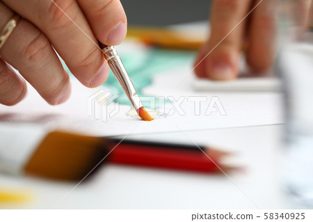 Male hand making drawing with watercolor brush 58340925