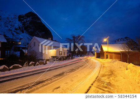 Road in Ramberg village with red traditional rorbue houses in the night, Norway 58344154