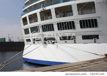 Close-up tail view of big modern white cruise ship liner morred with mooring cable at cargo port of 58345140