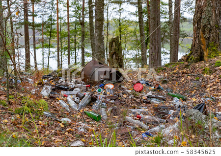Pile of garbage left by tourists by the lake, environmental pollution concept Pile of garbage left by tourists by the lake, environmental pollution concept 58345625