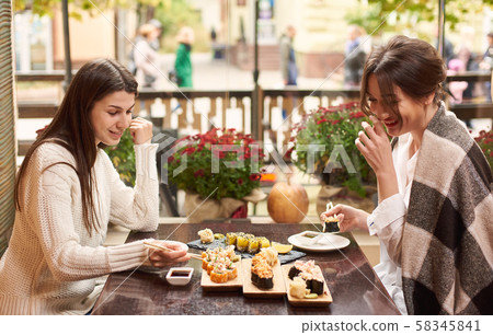 Friends meeting in oriental restaurant and enjoying dinner. 58345841