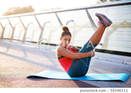 Dark-haired woman making funny face while doing yoga 58346111