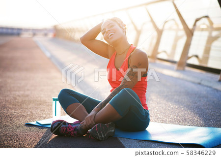 Woman with tattoo on arm loving sport practicing yoga outside 58346229
