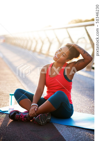 Dark-skinned woman stretching neck while doing yoga 58346230