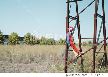 scary clown on an abandoned billboard. 58347150
