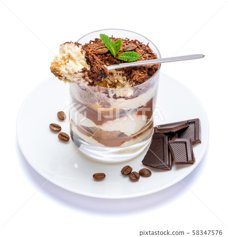 Classic tiramisu dessert in a glass cup on the plate and pieces of chocolate on white background 58347576