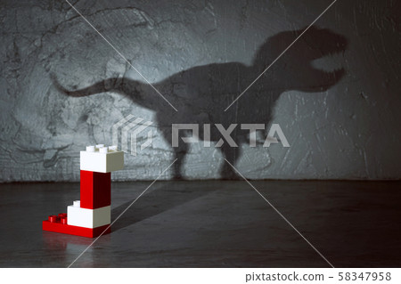 Plastic building blocks with dinosaur shadow . Creative and ideal concept . Concrete interior background . Plastic building blocks with dinosaur shadow . Creative and ideal concept . Concrete interior background . 58347958