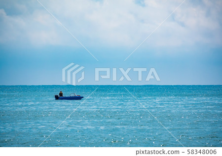 A fisherman is sailing in a boat. 58348006