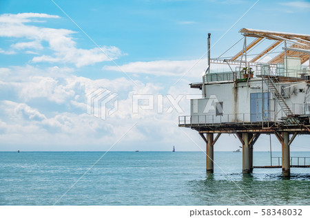 Platform on supports in the sea near the shore. 58348032