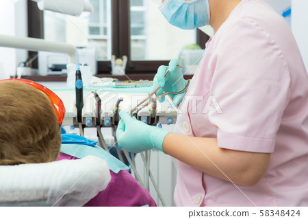 The dentist prepares a latex scarf with metal The dentist prepares a latex scarf with metal 58348424