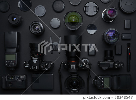 Flat lay top view of many various unknown brand camera,lens and photography equipment on black background . Flat lay top view of many various unknown brand camera,lens and photography equipment on black background . 58348547